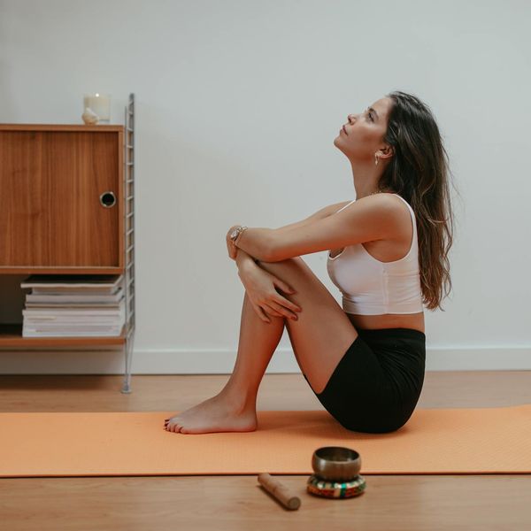 Person stretching with focus and calm expression in a minimalist environment.